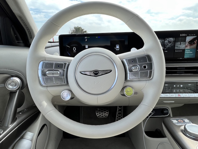 The steering wheel in the Genesis GV60; the yellow button activates Boost Mode