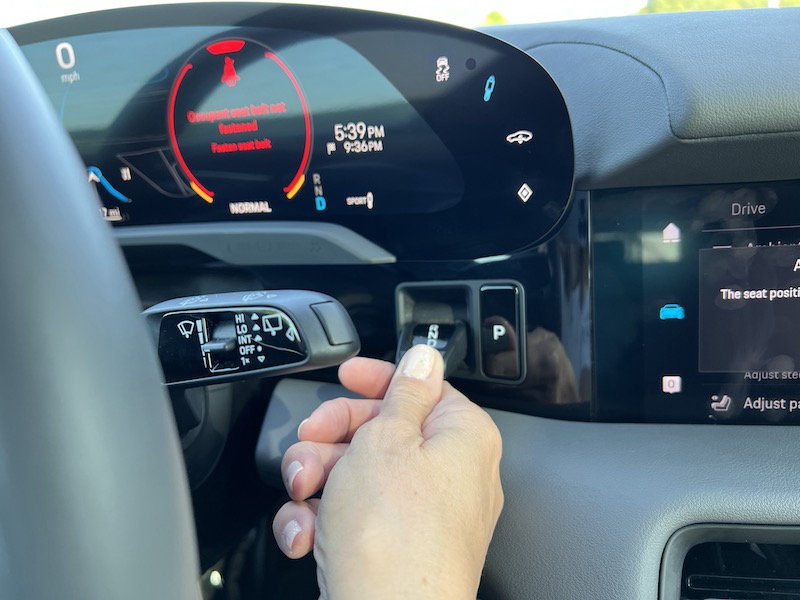 The drive mode selector is a small toggle to the right of the steering wheel