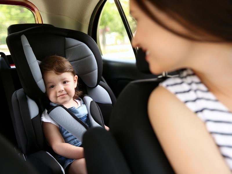 Mom in car looking back and baby in car seat