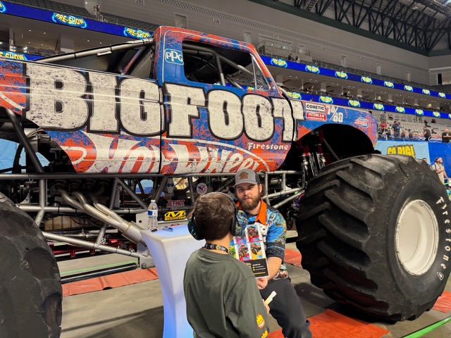 Hot Wheels Monster Trucks Live Glow Party Was the Boy-Mom Delight I Didn't Know I Needed 5 The Bigfoot Monster Truck, Its Driver, And A Young Boy Excited To Meet The Driver And Collect His Autograph