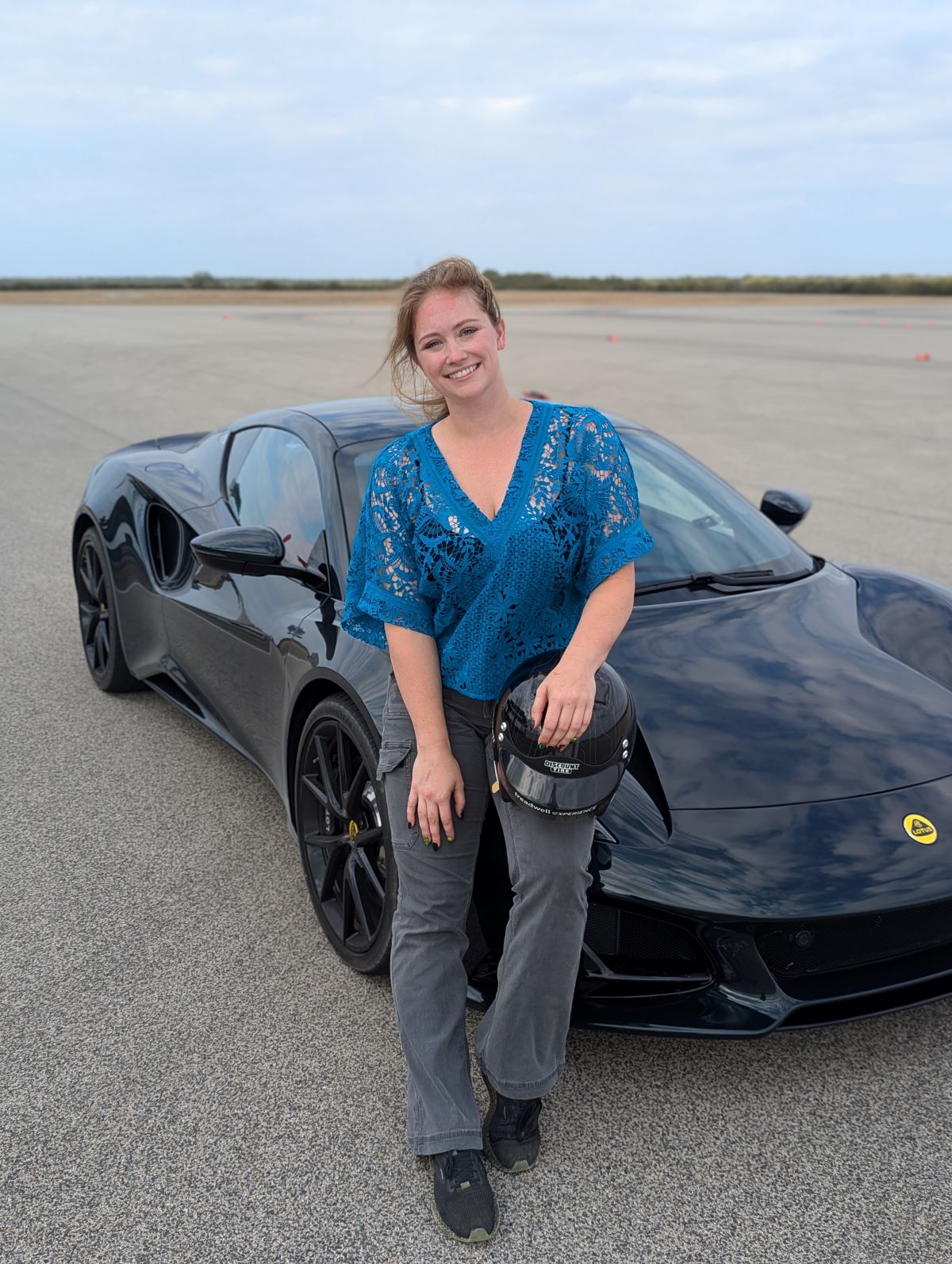 I Went to Tire Testing School With Discount Tire's Treadwell Team and Was Shocked At What I learned 11 Annika Sitting On A Lotus Emira Holding A Helmet Before Testing Tires At The Treadwell Experience