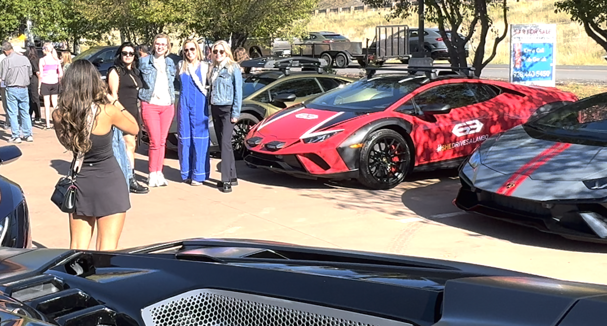 Some In The Group Posing For Photos With Their Cars