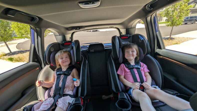 Two toddlers smiling in the back seat of the 2025 Subaru Forester hybrid