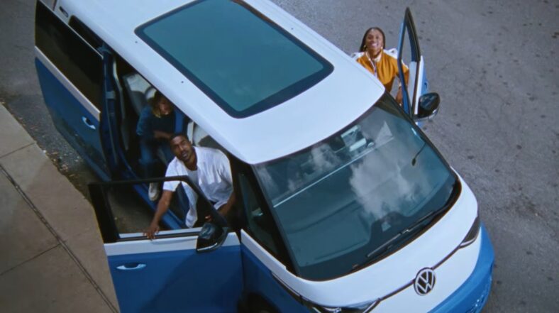 A Group Of Young People Waving Their Friend To Join Them In A Vw Id.buzz